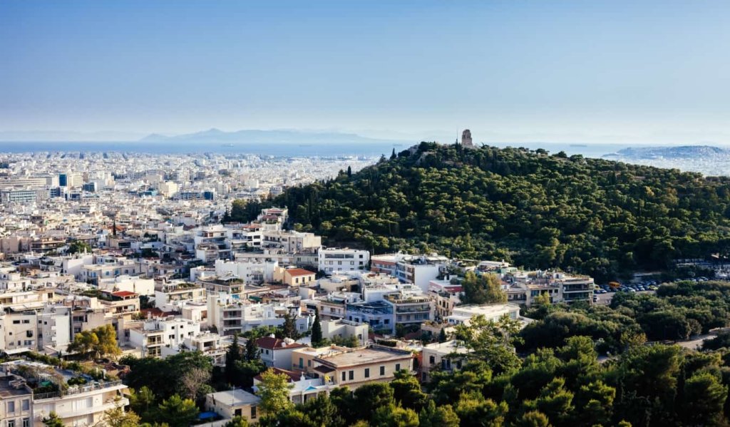 Athens cityscape with white buildings and large, forested hill