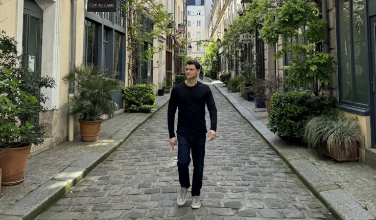 Nomadic Matt walking down a cobblestone street in Paris, France