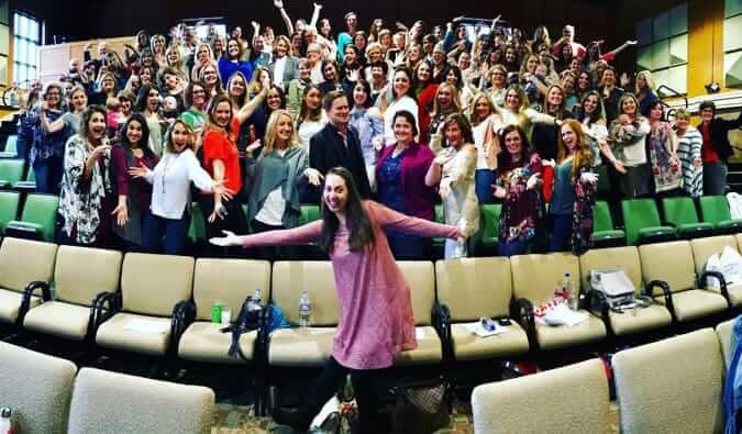 best-selling author Vanessa Van Edwards posing with an audience of people behind her in an auditorium